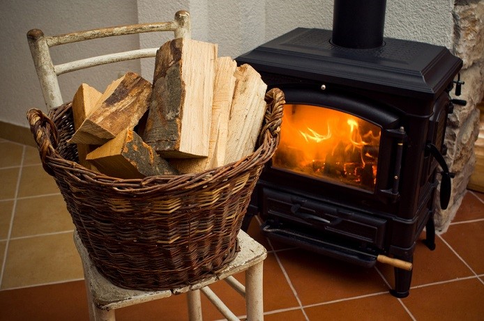 Basket full of logs in front of burning fire
