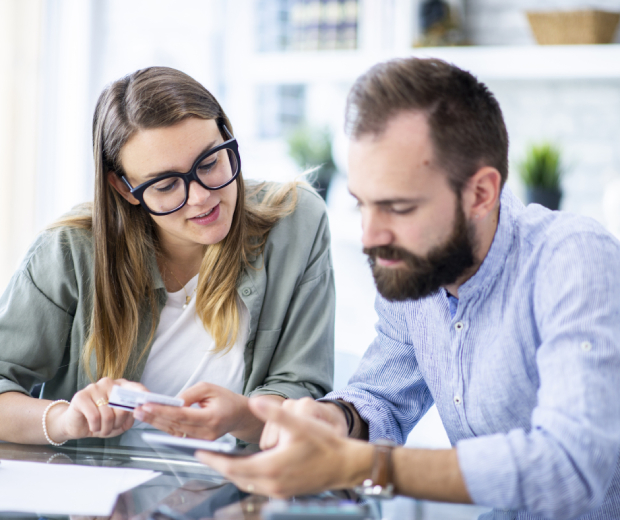 A young couple in Winchester, MA, reviewing their insurance policy and financial plans together on a tablet.