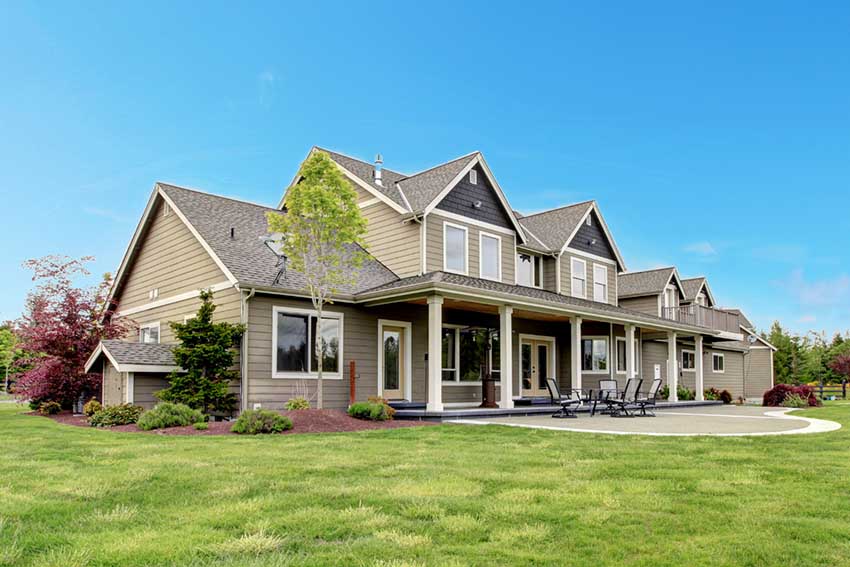 Large modern two-story suburban house with beige siding - https://johnpierceinsurance.com